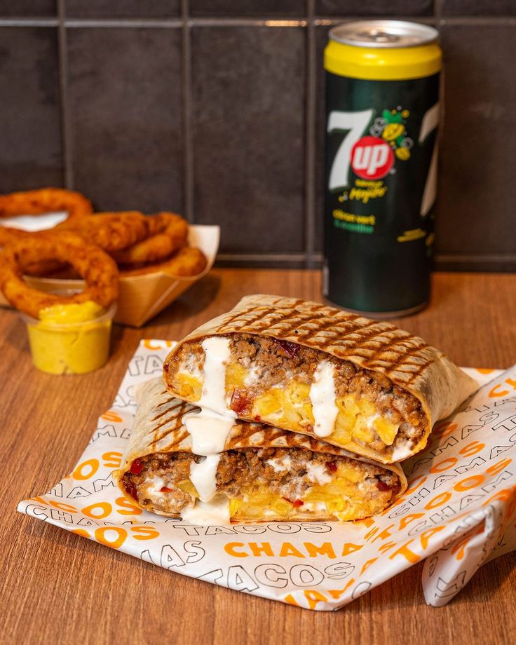 Tacos coupé en deux garni de viande hachée et de sauce fromagère, servi avec des onion rings
