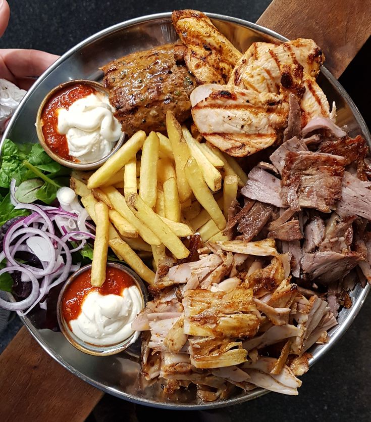 Grand plat de viandes grillées, frites, salade, oignons rouges et sauces